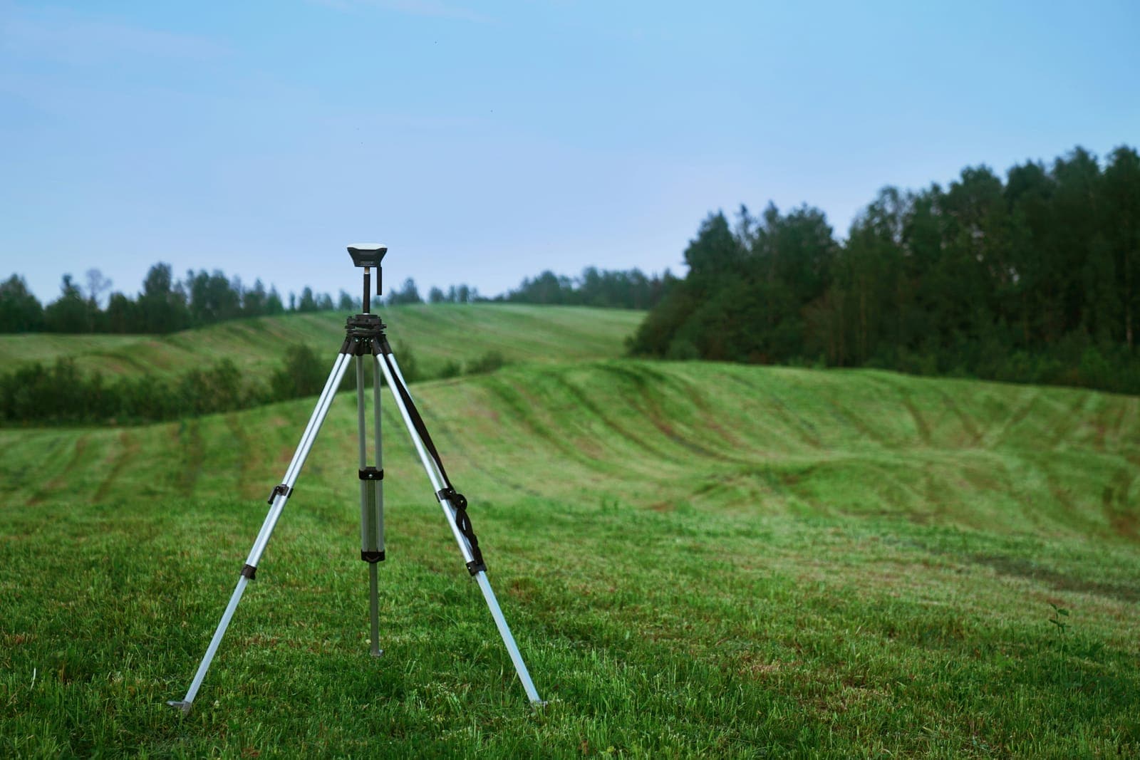 Land surveyors measuring terrain with GNSS equipment
